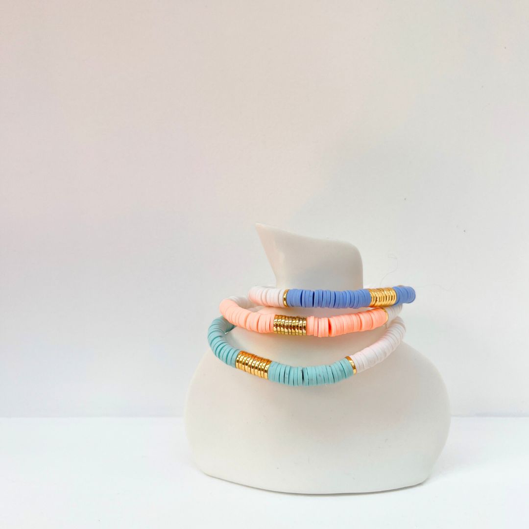 White stacking bracelets on white vase