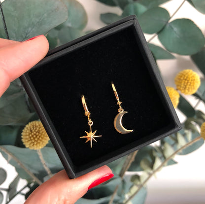 Tiny hoop earrings, one with a star, one with a moon